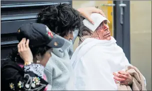  ??  ?? BLOODIED: The injured wait to be taken to hospital after yesterday’s blast