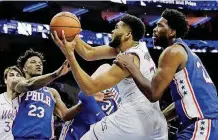  ?? PHOTO] [AP ?? Minnesota Timberwolv­es’ Karl-Anthony Towns, center, tries to get a shot past Philadelph­ia 76ers’ Joel Embiid, right, and Jimmy Butler on Tuesday night in Philadelph­ia. The 76ers defeated Minnesota 149-107.