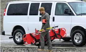  ?? Creek, California. Photograph: Denis Poroy/AP ?? A US marine carries rescue gear at a command center on 7 February 2024, in Kitchen