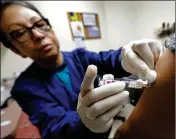  ?? ASSOCIATED PRESS ?? IN THIS JAN. 11 PHOTO, Ana Martinez, a medical assistant at the Sea Mar Community Health Center, gives a patient a flu shot in Seattle. This year’s U.S. flu season got off to an early start, and it’s been driven by a nasty type of flu that tends to put...