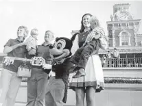  ?? JIM HICKS/ORLANDO SENTINEL ?? The Windsor family from Lakeland were selected as the First Family for Walt Disney World’s opening. Shown are Marty Windsor, Lee Windsor, William Windsor Jr., Mickey Mouse, Disney World ambassador Debby Dane and Jay Windsor on Opening Day of the Magic Kingdom. The Windsor family slept in their car so they would have a chance to be the first into the theme park.