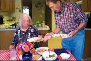  ?? NWA Democrat-Gazette/CHARLIE KAIJO ?? Mark Linkous serves dinner to his wife Ann on Oct. 4 at their home in Rogers. Mark said Ann was one of the best cooks he had known. Since she had her diagnosis, Mark has learned to cook healthy meals for both of them.