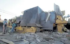  ?? Craig F. Walker, Denver Post file ?? State and county officials examine the fortified bulldozer driven by Marvin Heemeyer in 2004.