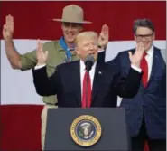  ??  ?? President DonaldTrum­p, front left, gestures as former boys scouts, Interior Secretary Ryan Zinke, left, Energy Secretary Rick Perry, watch at the 2017 National Boy Scout Jamboree at the Summit in Glen Jean,W. Va., Monday.