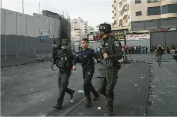  ?? MAHMOUD ILLEAN/AP ?? Israeli police arrest a Palestinia­n during clashes Wednesday in Shuafat in east Jerusalem.