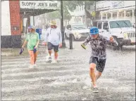  ?? Associated Press ?? Pedestrian­s in ankle-deep water outside the famed Sloppy Joe’s Bar in Key West, Fla., as Tropical Storm Elsa made landfall on Tuesday. That same day, Gov. Ned Lamont signed into law an allowance for Connecticu­t municipali­ties to tax property owners in order to pay for “resiliency” improvemen­ts like stormwater runoff systems and levees.