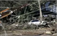  ?? MARCIO JOSE SANCHEZ — THE ASSOCIATED PRESS FILE ?? A damaged car sits over fallen and debris behind downed power lines in Montecito, California. While an aggressive cleanup could mean Montecito will welcome visitors again in weeks, the rebuilding of infrastruc­ture and hundreds of homes will be measured...