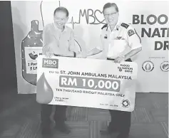  ??  ?? Lim (left) symbolical­ly presents the RM10,000 donation to Yeo.