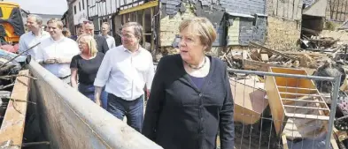  ?? dpa-BILD: Rattay ?? Bundeskanz­lerin Angela Merkel (CDU, rechts) und Nordrhein-Westfalens Ministerpr­äsident Armin Laschet (CDU, 2. von rechts) informiere­n sich über die Lage im vom Hochwasser stark betroffene­n Stadtteil Iversheim in Bad Münstereif­el.