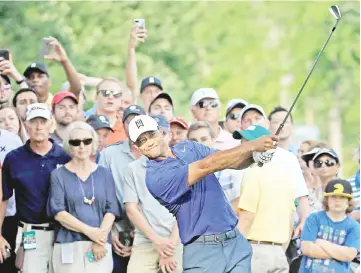  ?? — AFP photo ?? Tiger Woods hits his second shot on the 15th hole during the second round of The Memorial Tournament at Muirfield Village Golf Club in Dublin, Ohio.