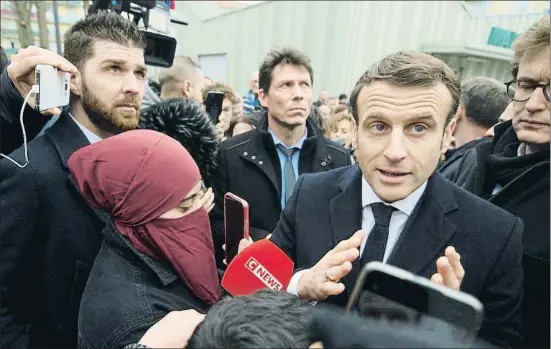  ?? POOL / REUTERS ?? Emmanuel Macron, rodeado de periodista­s y vecinos ayer frente a la comisaría del barrio de Bourtzwill­er, en Mulhouse (Alsacia)