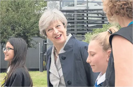  ?? Picture: Getty. ?? Prime Minister Theresa May with pupils Miya Herbert, left, Katie Davies, right, and head teacher Dr Helen Holman at Orchard School in Bristol yesterday.