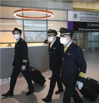  ?? NICOLAUS CZARNECKI PHOTOS / HERALD STAFF ?? MASK PORT: Crew members and passengers, right, from Thursday’s Hainan Airlines flight from Shanghai pass through Logan Internatio­nal Airport. Below right, the Hainan flight taxis to the gate.