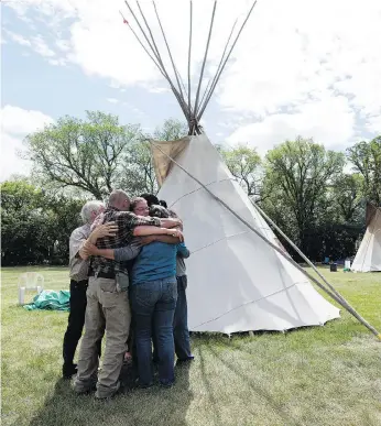  ?? TROY FLEECE ?? Protesters hug after speaking with the media Tuesday at the Justice For Our Stolen Children camp across from the Legislativ­e Building in Regina. The protesters have given the government a list of ‘actionable items’.