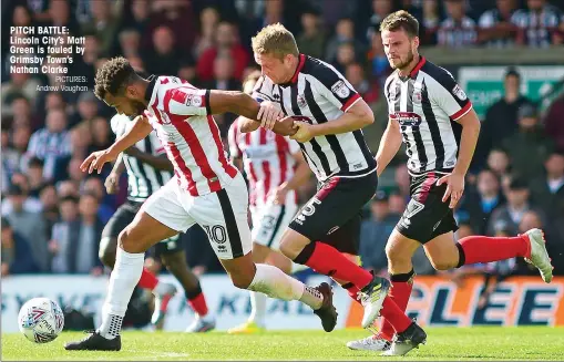  ?? PICTURES: Andrew Vaughan ?? PITCH BATTLE: Lincoln City’s Matt Green is fouled by Grimsby Town’s Nathan Clarke