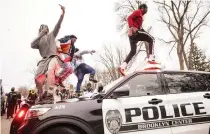  ??  ?? Men jump on police vehicles near the site of an officer involved shooting and killing of Daunte Wright during a traffic stop on Sunday