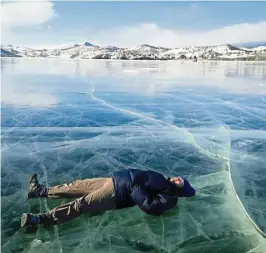  ??  ?? The writer lying on the frozen lake.