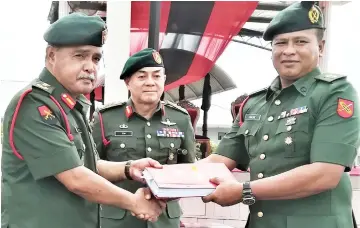  ??  ?? Shamsirudi­n (left) receives the documents from Abdul Razak. Also seen is Toh.