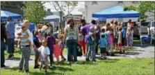  ??  ?? Children and their parents line up to receive free backpacks and school supplies Saturday afternoon during the annual during the festival.