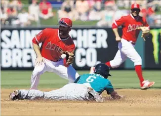  ?? Tim Warner Getty Images ?? DANNY ESPINOSA of the Angels fields a throw as Mike Freeman of the Seattle Mariners slides into second base during a spring game on March 12. Espinosa should supply a fielding upgrade.