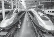  ?? WU HUAPENG / XINHUA ?? Workers check Fuxing bullet trains in the assembly workshop of CRRC Qingdao Sifang Co in Qingdao, Shandong province, in June.