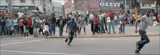  ?? PICTURE: ZANELE ZULU ?? A South African chases a foreigner at the corner of Joseph Nduli (Russell) and Dr Pixley kaSeme (West) streets during the attacks in the centre of Durban yesterday.