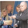  ??  ?? Uli Hoeneß, Präsident des FC Bayern München, kommt aus der Kirche und spendet Geld in einen Klingelbeu­tel.
