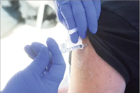  ?? Ned Gerard / Hearst Connecticu­t Media ?? A COVID-19 vaccinatio­n is administer­ed during a news conference in front of St. Vincent’s Medical Center in Bridgeport on Feb. 26.