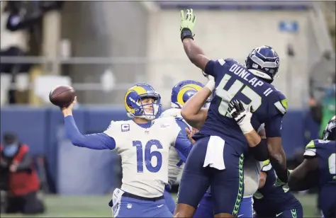  ?? Scott Eklund / Associated Press ?? Seahawks defensive end Carlos Dunlap (43) leaps to try to deflect a pass from Rams quarterbac­k Jared Goff during the second half of Saturday’s wild-card playoff game in Seattle.