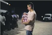  ?? Gregory Bull Associated Press ?? A COLOMBIAN man holds his baby daughter after crossing into the U.S. near Yuma, Ariz.