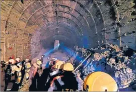  ?? AP ?? ITBP personnel use torches in a tunnel where over three dozen workers are trapped.