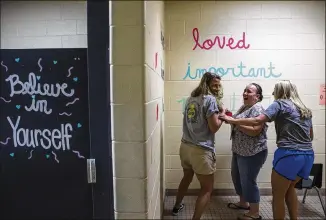  ?? AMANDA VOISARD / AMERICAN-STATESMAN ?? Lost Pines Elementary third-grade teacher Beth Brooks (from left), fourth-grade teacher Heather Moore and Principal Melinda Gardner paint messages in a school restroom.