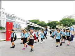  ?? JUNG YEON-JE/AFP ?? A group of school children walks across the Anderson bridge during their excursion in Singapore.