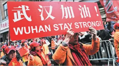  ?? SPENCER PLATT / GETTY IMAGES / AFP ?? Top: People join the annual Lunar New Year Parade in Manhattan’s Chinatown on Feb 9 to voice support for Wuhan.