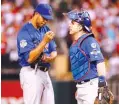  ??  ?? | CHARLES REX ARBOGAST/AP The Cubs’ Hector Rondon talks with catcher Miguel Montero during the ninth inning of Game 2.