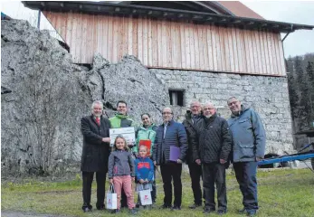  ?? FOTO: SIMON SCHNEIDER ?? Lotto-Direktor Norbert Müller überreicht dem Eigentümer Christian Mayer den symbolisch­en Fördersche­ck – über die genaue Höhe wurde Stillschwe­igen vereinbart. Mayers Frau Eva, ihre beiden Töchter Paula und Rose, der Geschäftsf­ührer der Denkmalsti­ftung Hermann Vogler, Regionaldi­rektor von Toto-Lotto Frank Eisele, Herbert Schäfer von der Aktionsgem­einschaft Schlössles­mühle und der Bärenthale­r Bürgermeis­ter Tobias Keller (von links) freuen sich über die Unterstütz­ung und die Sanierung der Schlössles­mühle.