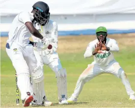  ?? LENNOX ALDRED ?? Combined Campuses and Colleges batsman Jonathan Carter gets ready to cut while Jamaica Scorpions captain Jermaine Blackwood looks on during their West Indies Championsh­ip match at Sabina Park yesterday.