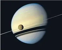  ?? Photo: REUTERS ?? The target: Titan, Saturn’s largest moon appears before the planet as it undergoes seasonal changes in this natural colour view from Nasa’s Cassini spacecraft.