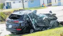  ?? JOE CAVARETTA/SOUTH FLORIDA SUN SENTINEL ?? The SUV that was struck by an airplane Monday is seen behind police tape on a residentia­l street near North Perry Airport in Pembroke Pines on Tuesday.