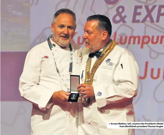  ??  ?? > Arwyn Watkins, left, receives the President’s Medal from Worldchefs president Thomas Gugler