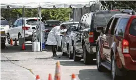  ?? Jon Shapley / Staff photograph­er ?? Medical workers talk with people waiting for COVID-19 tests last month at United Memorial Medical Center. Residents have been urged to get COVID-19 testing done before they may have to enter a crowded storm shelter.