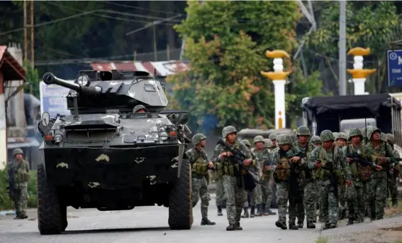 ??  ?? Marines advance their position against a group of militants in Marawi yesterday (Reuters)
