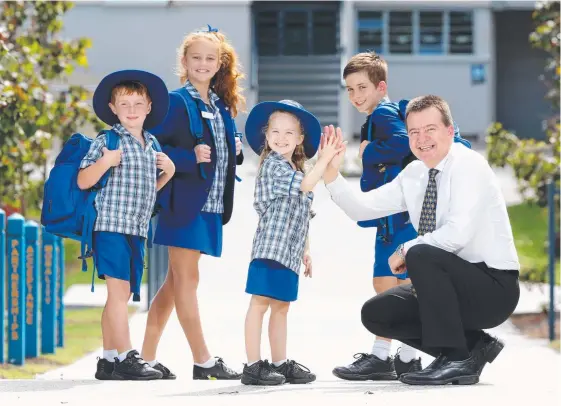  ?? Picture: AAP ?? Pimpama State School principal Marius Marx gets a high five from Madison Woolf, watched by Ethan Rosser, Isabella Seery and Ryan Argue.