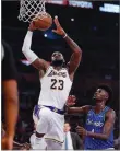  ?? AP PHOTO BY MARK J. TERRILL ?? Los Angeles Lakers forward Lebron James, left, shoots as Orlando Magic forward Jonathan Isaac defends during the first half of an NBA basketball game Sunday, Nov. 25 in Los Angeles.