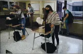  ?? JESSICA HILL — THE ASSOCIATED PRESS FILE ?? Students in teacher Christophe­r Duggan’s science class clean their work areas at the end of class at Windsor Locks High School in Windsor Locks, Conn.