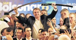  ?? HEDESON ALVES/EFE ?? Presidenci­ável. Bolsonaro recebe uma espada ao participar de evento em Curitiba