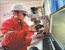  ?? JIN TIAN / FOR CHINA DAILY ?? Wang Xiaoming, a technician from the Tarim Oilfield Experiment­al Testing Institute, observes rock samples through a microscope.