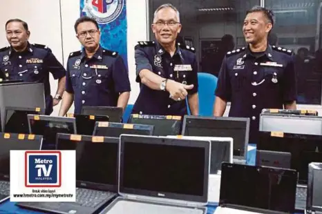  ??  ?? ABD Aziz (dua dari kanan) bersama pegawainya menunjukka­n komputer riba, mesin pencetak dan komponen komputer yang dirampas pada sidang media, semalam.