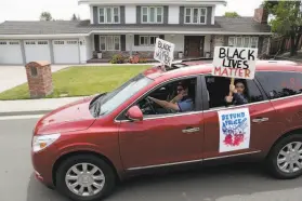  ??  ?? James Campbell and his daughter Kate participat­e in a Black Lives Matter car caravan protest that stopped at the home of the Contra Costa sheriff.