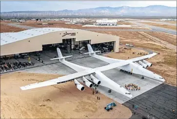  ?? Stratolaun­ch Systems Corp. ?? A STRATOLAUN­CH airplane capable of launching satellites emerges from its hangar in Mojave, Calif.